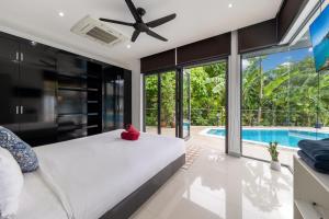 a bedroom with a bed and a swimming pool at 4BR Luxury Pool Retreat - Villa Azura Nai Harn in Nai Harn Beach