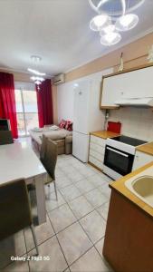 a kitchen with a table and a kitchen with a couch at Apartman Malvina in Flogita