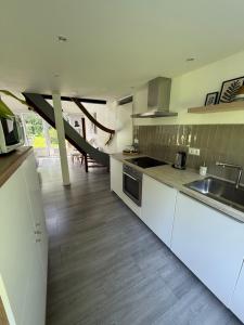 a kitchen with white cabinets and a sink and a counter at Vakantiewoning Sjun Limburg in Simpelveld