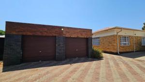 two garage doors on the side of a brick building at Rams Blissful Guest House in Rustenburg