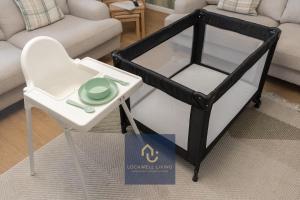 a black and white bed with a table and a chair at Chalfont Haven in Latimer