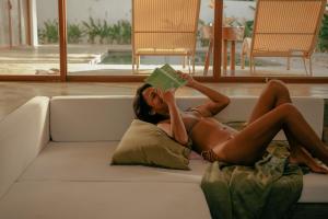 eine Frau, die auf einer Couch liegt und ein Buch liest in der Unterkunft Don Luis in Alegria