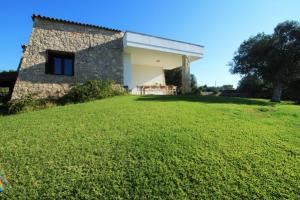 サルヴェにあるVilletta Rosemaryの芝生の庭のある石造りの家の景色