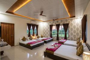 a bedroom with three beds in a room at Vanveli The Forest Resort in Sasan Gir +49 photos