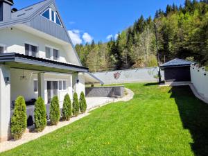 a yard with a white house and bushes at My sweet home Vrhpraca Jahorina in Jahorina