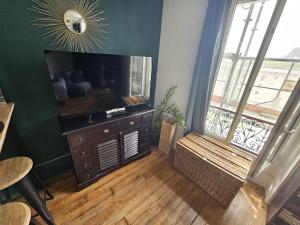 a living room with a flat screen tv and a window at Bel Apt châteaux de Vincennes in Vincennes