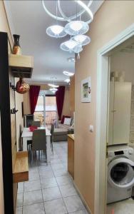 a kitchen and living room with a washing machine in a room at Apartman Malvina in Flogita