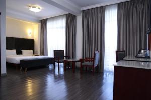 a hotel room with a bed and a table and chairs at Trinity Hotel in Addis Ababa +74 photos