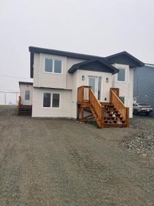 a white house with a porch and a deck at Modern 2BR Suite, Wifi, Workstation and Comfy Beds in St. John's