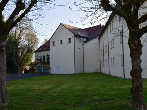 a large white building with a large yard at Hôtel Ibis Nevers in Nevers