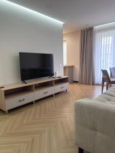 a living room with a flat screen tv on a entertainment center at Modern Apt in Shymkent