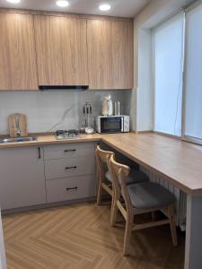 a kitchen with a table and two chairs and a microwave at Modern Apt in Shymkent +12 photos