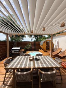 a wooden deck with a table and a grill at Le 25 Bis Spa&Sauna aux portes de Montauban in Lamothe-Capdeville