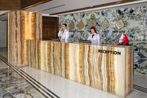 zwei Personen stehen an der Rezeption in einer Lobby in der Unterkunft B Business Hotel & Spa in Antalya + 28 Fotos