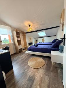 a bedroom with a blue bed and a wooden floor at Le 25 Bis Spa&Sauna aux portes de Montauban in Lamothe-Capdeville +38 photos