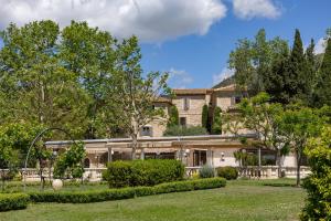 an exterior view of a large house with trees at Le Mas de Guilles in Lourmarin