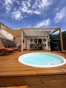 a large pool on a wooden deck with a house at Le 25 Bis Spa&Sauna aux portes de Montauban in Lamothe-Capdeville