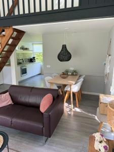 a living room with a couch and a table at Vakantiewoning Sjun Limburg in Simpelveld +15 photos