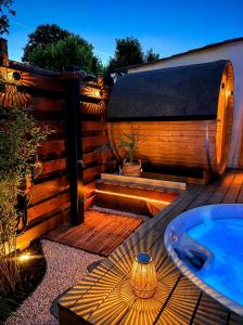 a wooden deck with a hot tub and a jacuzzi at Le 25 Bis Spa&Sauna aux portes de Montauban in Lamothe-Capdeville
