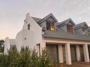 a white house with a gray roof at Farside Macadamias in Riversdale