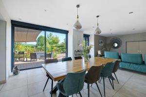 a dining room and living room with a wooden table and chairs at Gite Du Bois in Ponts
