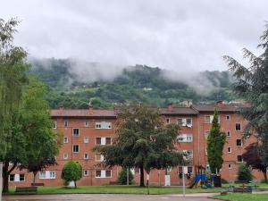 a large brick building with a mountain in the background at CASA RAMI especial parejas in San Martín del Rey Aurelio