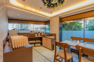 eine Küche mit Tisch, Stühlen und Fenstern in der Unterkunft Hotel 7 skye in Surat