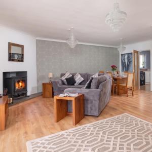 a living room with a couch and a fireplace at Four Oaks Cottage in Rockcliffe
