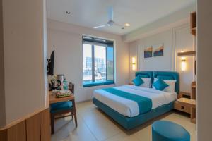 ein Schlafzimmer mit einem blauen Bett und einem Fenster in der Unterkunft Hotel 7 skye in Surat