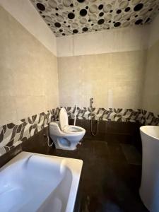 a bathroom with a toilet and a bath tub at Prime Stay Bosan Hotel Multan in Multan