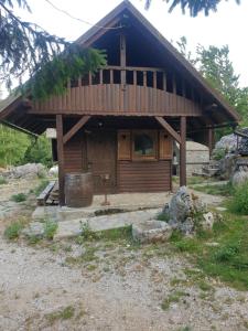 a log cabin with a barrel in front of it at Apartma Vidmar Otlica in Ajdovščina