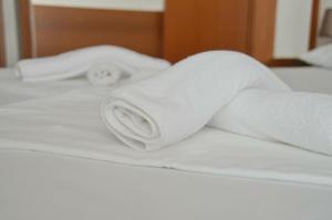 a roll of white towels sitting on a bed at Gec II in Ivanec Bistranski