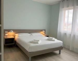 a bedroom with a bed with two towels on it at The Desdemona in Pordenone