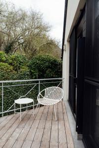 a white chair and a stool on a wooden deck at Hotel Château Palacio in Fauvillers