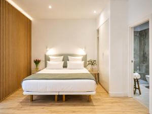 a bedroom with a large bed with white pillows at Paseo Suites Hotel in Madrid