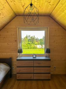 a bedroom with a window in a wooden house at Chatki Bies-Czadowe-Czad in Berezka