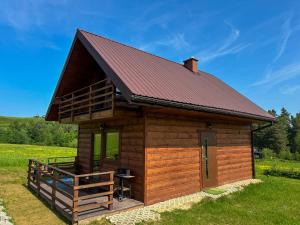 a small wooden cabin with a red roof at Chatki Bies-Czadowe-Czad in Berezka +9 photos