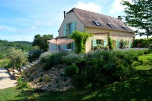 a house with a garden in front of it at Les Volets Verts-Dordogne in Plazac