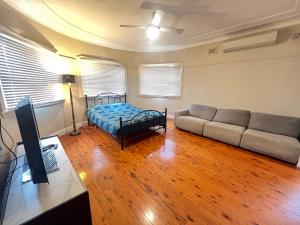 a living room with a couch and a bed at Room 78 in Merrylands