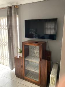 a tv in a room with a glass cabinet at Tortilla no 3 in Bloemfontein
