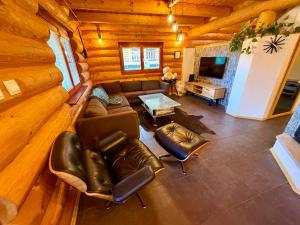 a living room with leather furniture in a log cabin at Wellness Chalet Tatry in Vysoké Tatry