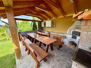 a kitchen with wooden tables and a fireplace at Wellness Chalet Tatry in Vysoké Tatry