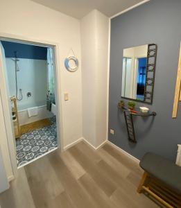 a hallway with a bathroom with a mirror at Gemütliche Ferienwohnung im Lotsenviertel in Cuxhaven
