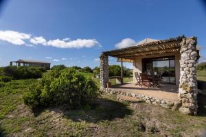 a stone cottage with a table and chairs outside at Thali Thali Game Lodge in Langebaan