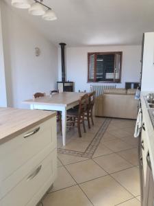 a kitchen and living room with a table and a stove at Domo Mea in Orgosolo