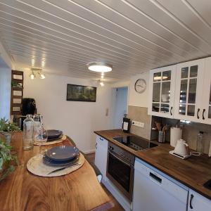 a kitchen with a wooden table with plates on it at Altenauer Kaffee-Chalet in Altenau