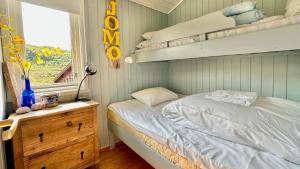 a bedroom with a bunk bed and a window at Atlantic Shoreline Cabin in Vestvågøya