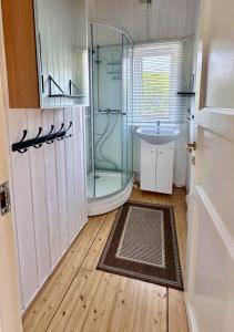 a bathroom with a shower and a sink at Atlantic Shoreline Cabin in Vestvågøya +33 photos