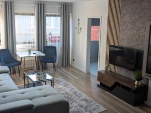 a living room with a couch and a tv at Gemütliche Ferienwohnung im Lotsenviertel in Cuxhaven