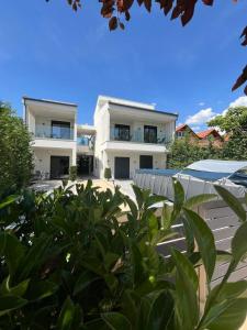 a white house with a lot of green plants at Mulberry Suites in Paralia Dionysiou